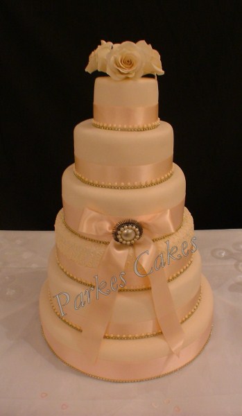 5 tier peach ribbon & brooch cake